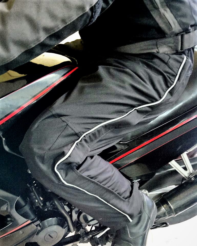 Sobrepantalon de moto Jama. Detalle de vivo reflectivo y vista de cierre lateral